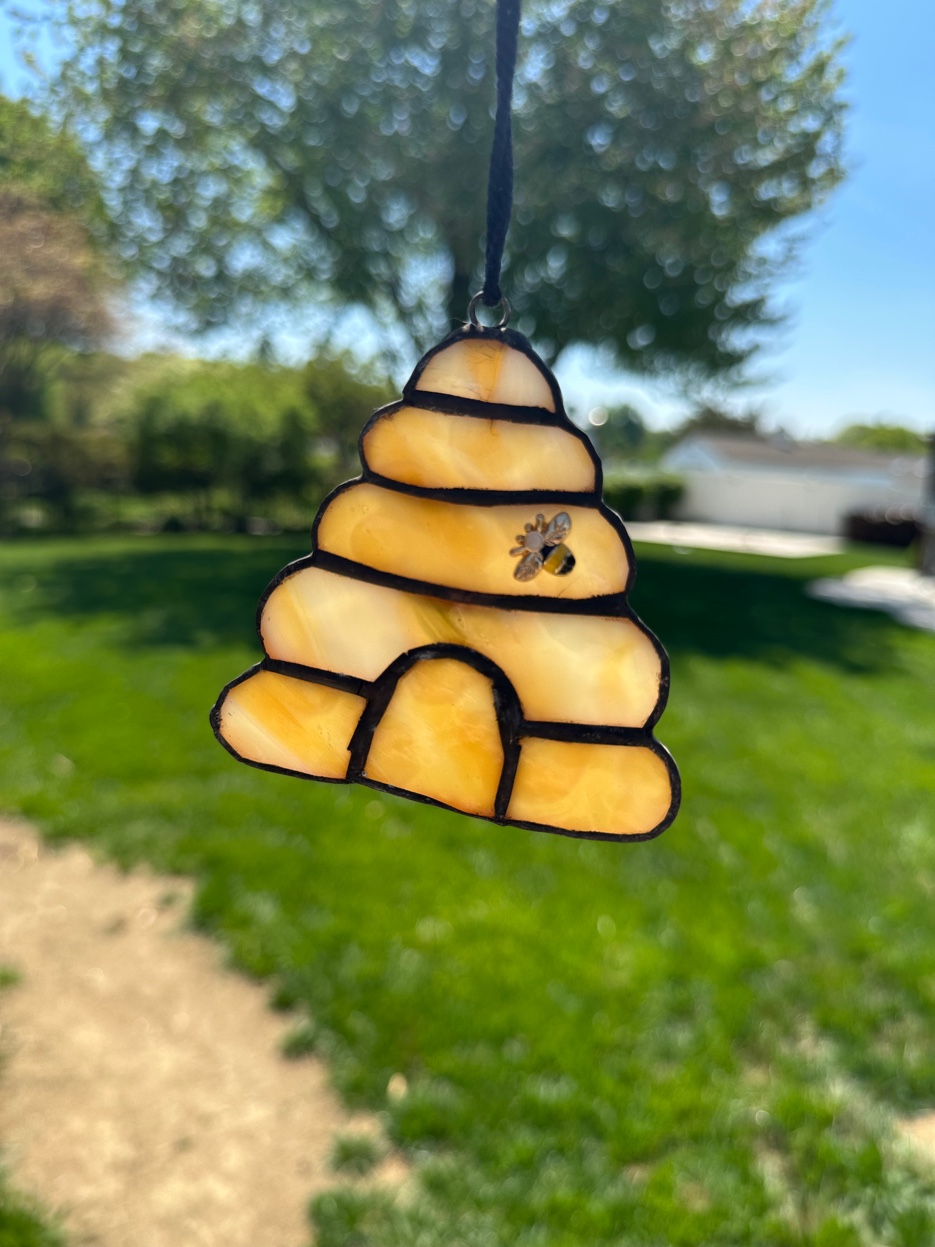 Amber stained glass beehive suncatcher with a small glass bee