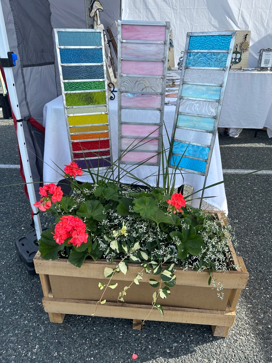 Racks of colored glass samples in blues, pinks, and iridescent tones